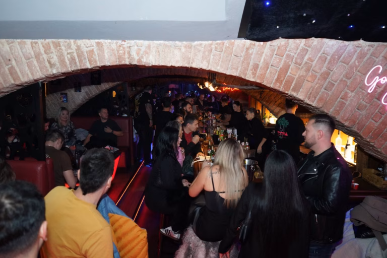 Plný bar pod cihlovým obloukem v Lavish Lounge