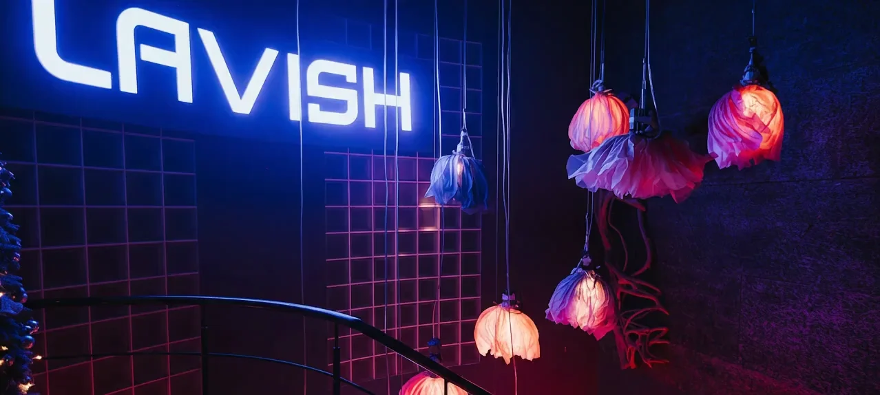 Vstup do Lavish Lounge – neon LAVISH nad schody